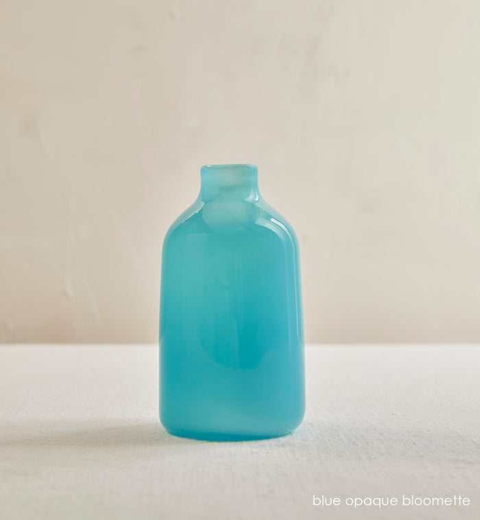 blue opaque bloomette, opaque blue hand-blown glass flower bud vase in a cream room.