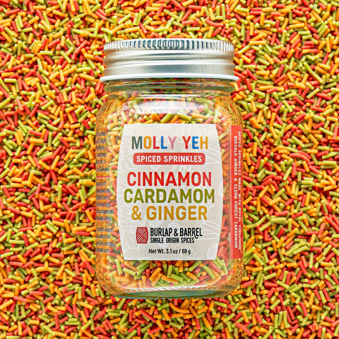 Jar of Molly Yeh & Burlap & Barrel Spiced Sprinkles with colorful sprinkles in the background
