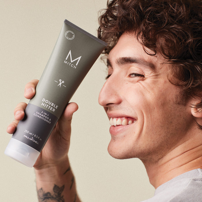 Mitch model holding bottle of Mitch Double Hitter near their face
