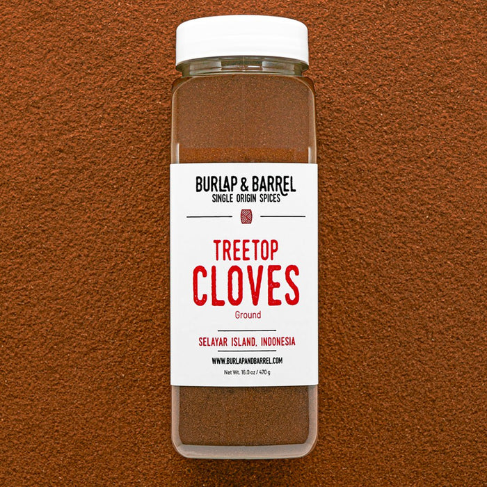 Container of Burlap & Barrel Treetop Cloves on a brown background
