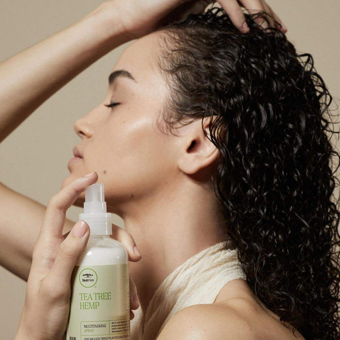 Tea Tree Hemp model dispensing Multitasking Spray into hair