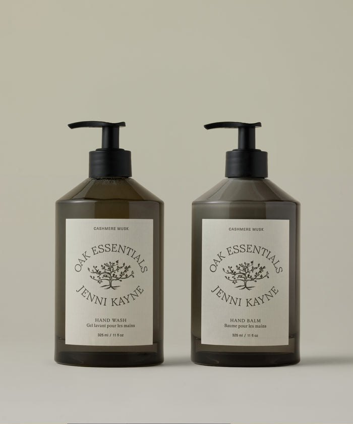 Two bottles of Oak Essentials Jenni Kayne hand care products on a beige background