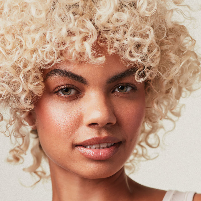 Paul Mitchell Blonde Collection female model with finished look on a neutral background