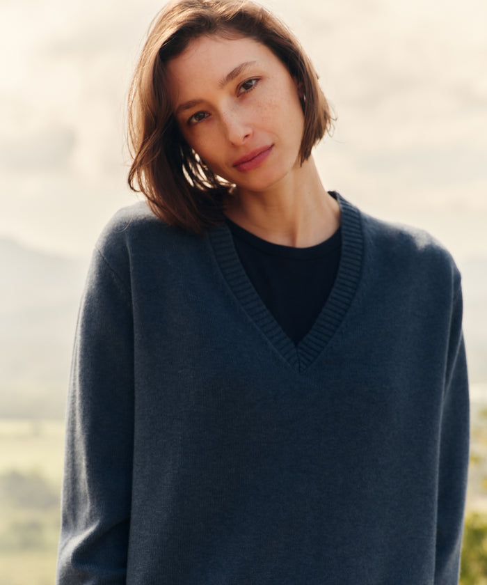 Woman wearing a navy v-neck sweater outside.