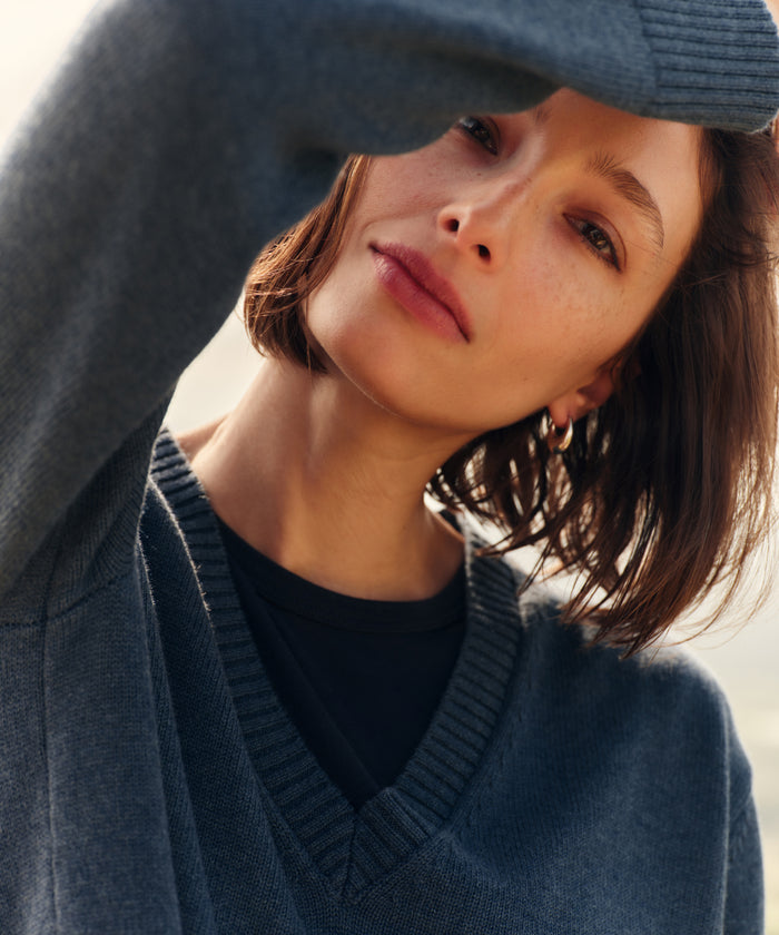 Woman wearing a navy v-neck sweater outside.