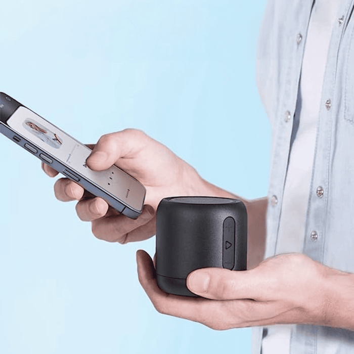 soundcore speaker with held beside smartphone