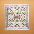 A multicolored, 100% cotton bandana with hand-drawn spice illustrations laid out flat on a surface.