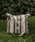 Striped tote bag with visible brand name on grass