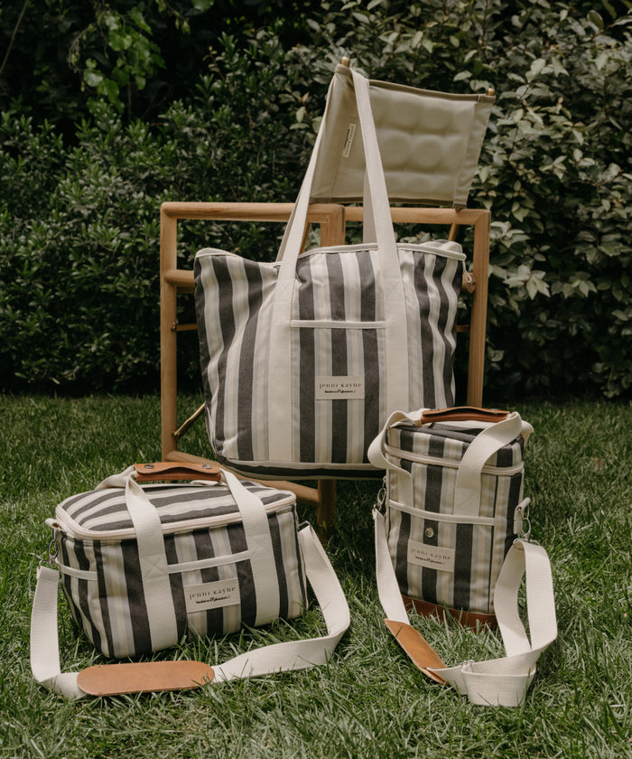Set of striped bags with leather accents on grass