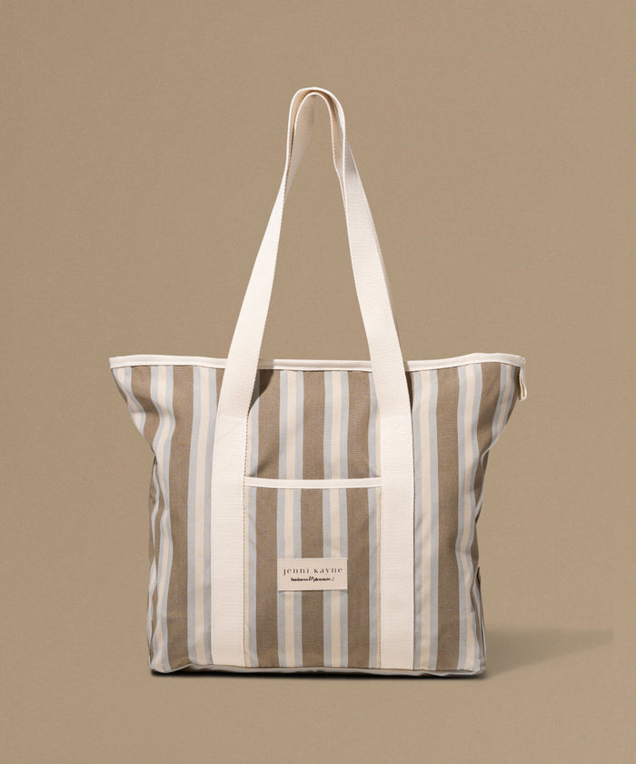 Striped tote bag with a visible brand label on a beige background