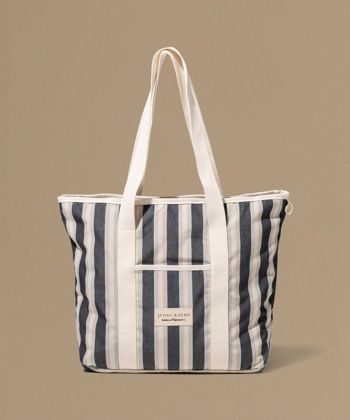 Striped tote bag with a visible brand label on a beige background