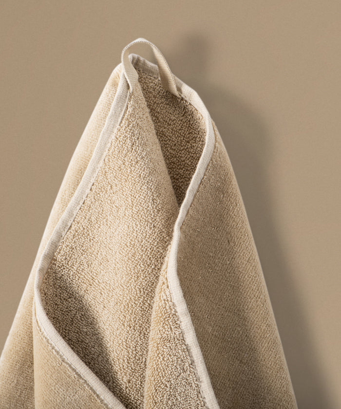 Beige towel hanging against a beige background