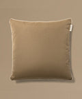 Brown pillow with a tag on a beige background