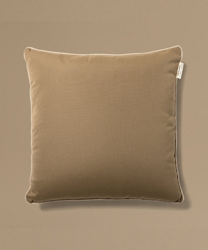 Brown pillow with a tag on a beige background