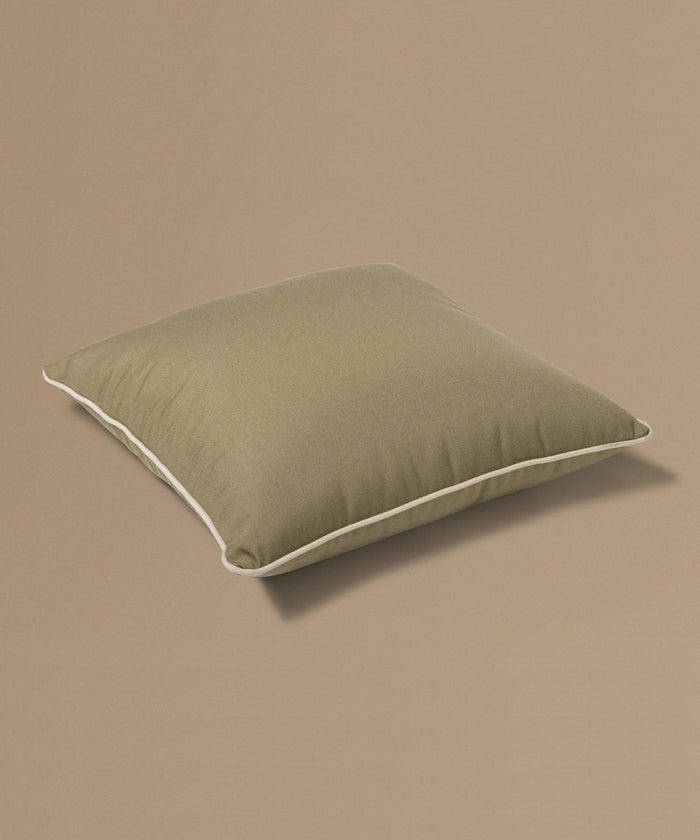 Brown pillow with a tag on a beige background
