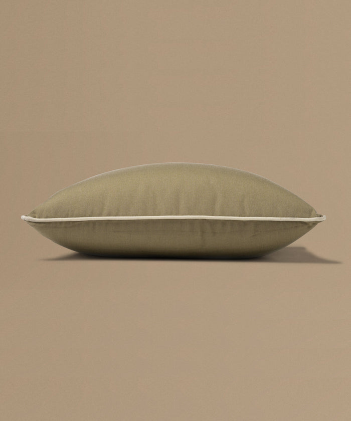 Brown pillow with a tag on a beige background