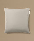 Gray pillow with a brand tag on a beige background