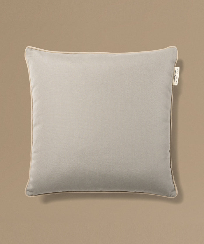 Gray pillow with a brand tag on a beige background