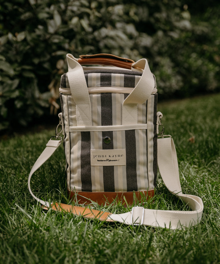 Striped cooler bag with leather accents on grass