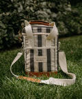 Striped cooler bag with leather accents on grass