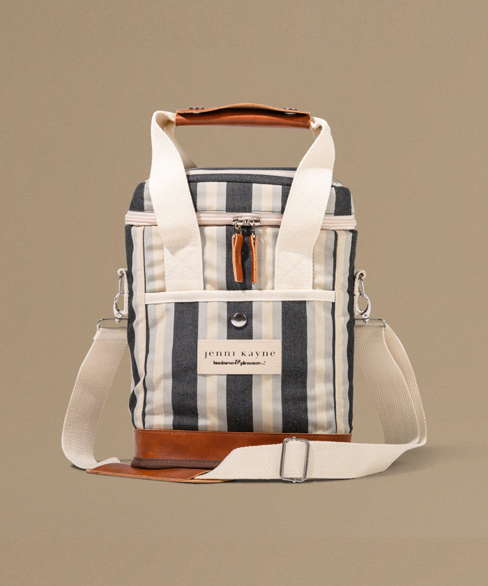 Striped cooler bag with leather accents on a beige background