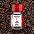 A bottle of Wild Timur Pepper by Burlap & Barrel, with the label showing the product name and origin, amidst loose peppers.